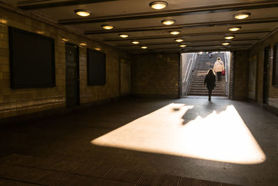 Rear view of women in illuminated subway