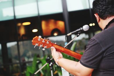 Rear view of man playing guitar