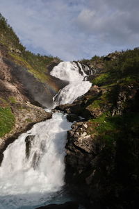 Scenic view of waterfall against sky