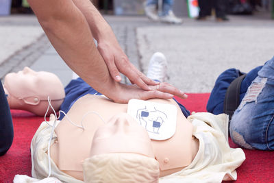 Midsection of person performing cpr on dummy