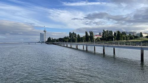 Scenic view of river by buildings against sky