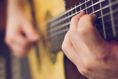 Cropped image of man playing acoustic guitar