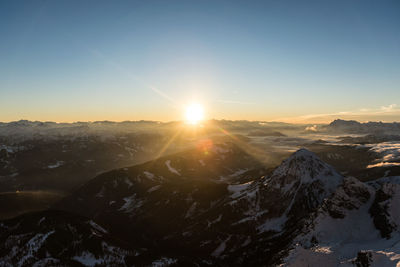 Scenic view of snowcapped mountains against clear sky during sunset