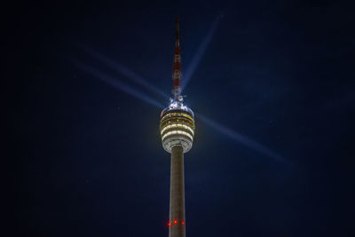 Stuttgart television tower against night sky with stars and light beams, germany