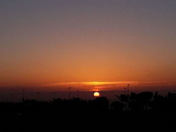 Silhouette landscape against orange sky