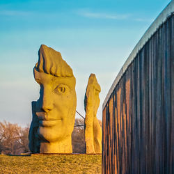 Statues against blue sky during sunset