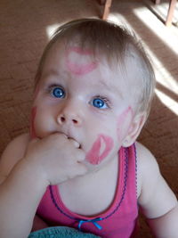 High angle view of cute baby boys with lipstick marks