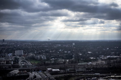 Aerial view of city against cloudy sky