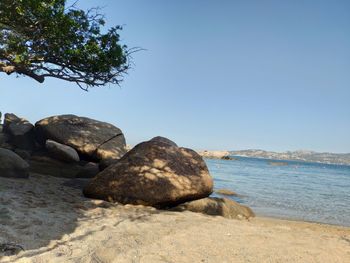 Rocks on beach against clear sky