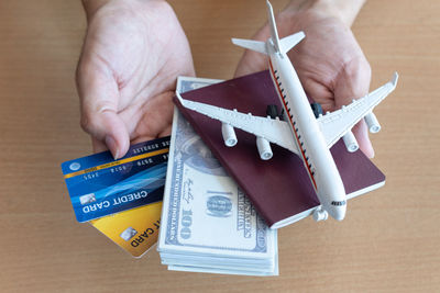 Close-up of hand holding money and passport