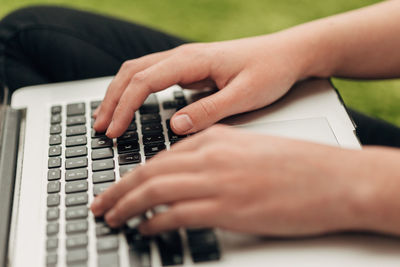 Cropped hands of woman playing piano
