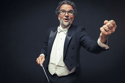 Midsection of man standing against black background