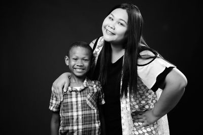 Portrait of happy friends against black background