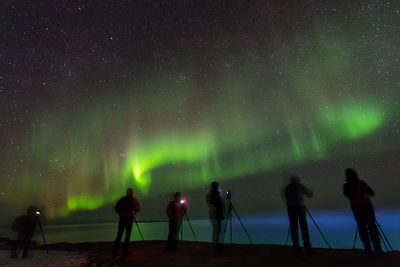 People photographing aurora borealis at night