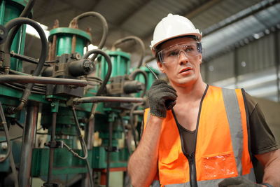 Portrait of male worker standing in the heavy industry manufacturing factory.