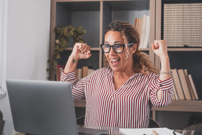 Woman using mobile phone while sitting in office