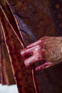 Close-up of woman's hand with red paint