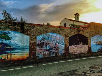 Graffiti on abandoned building against sky in city