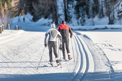 People skiing on snow covered landscape