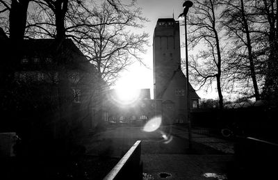 Bare trees against built structure