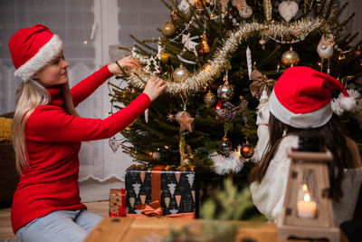 Rear view of woman holding christmas tree