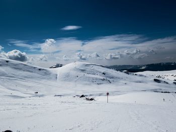 Scenic view of snowcapped mountains against blue sky