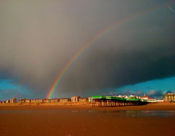 Scenic view of rainbow over city against sky