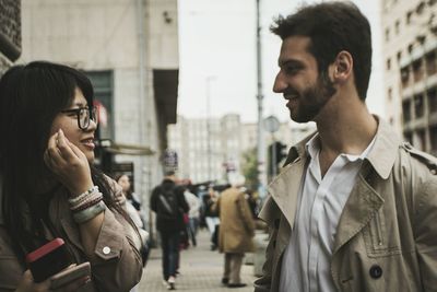 Friends talking while standing on city street