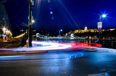 Illuminated light trails on city street at night