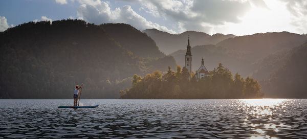 Scenic view of lake by mountains against sky