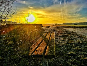 Close-up of water drops on farm against sky during sunset