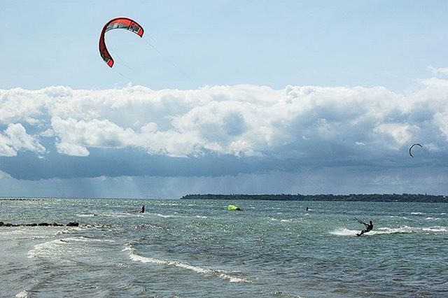 sea, flying, parachute, water, sky, mid-air, extreme sports, adventure, sport, paragliding, leisure activity, beach, waterfront, horizon over water, scenics, cloud - sky, tranquility, kiteboarding