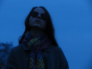 Low angle view of woman against blue sky