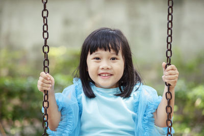 Portrait of girl on swing in playground