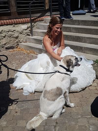 Woman with dog sitting outdoors