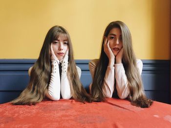 PORTRAIT OF A TEENAGE GIRL SITTING IN A ROOM