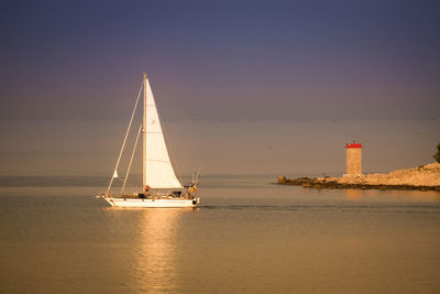 Sailboat sailing on sea against sky