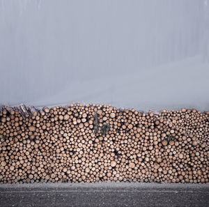 Stack of logs against sky