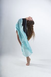 Side view of woman standing against white background