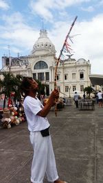 Man photographing in city against building