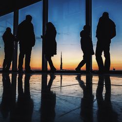 Silhouette of people in sea at sunset
