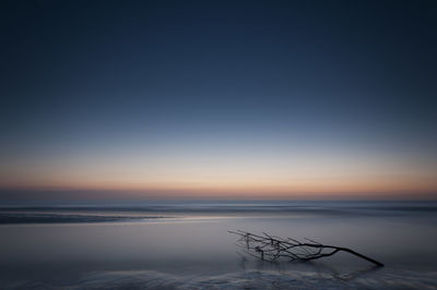 Scenic view of sea against clear sky at sunset