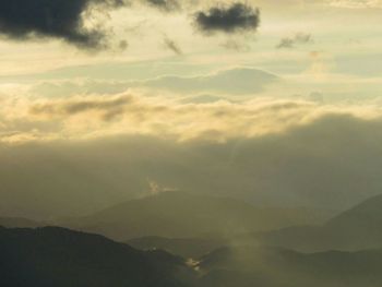 Scenic view of mountains against cloudy sky