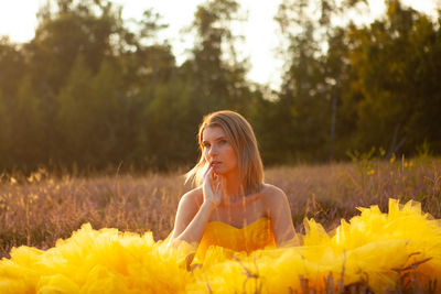 Portrait of young woman standing amidst plants