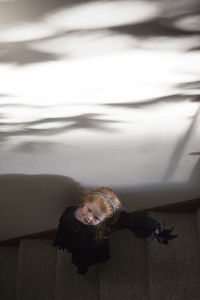 High angle view of girl in witch costume standing on steps