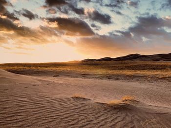 Scenic view of desert against sky during sunset