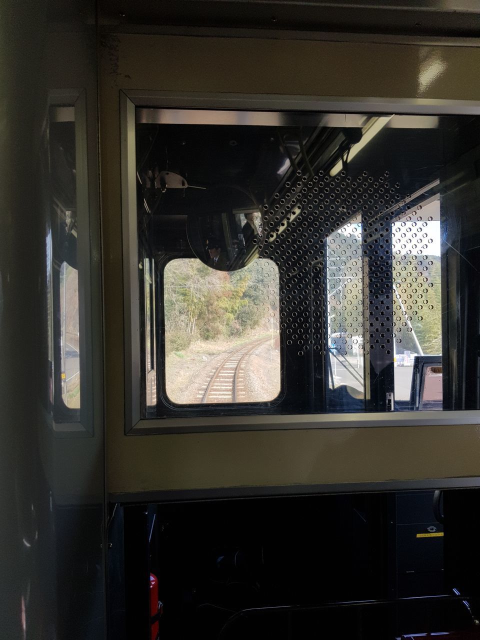 TRAIN SEEN THROUGH GLASS WINDOW OF RAILROAD STATION