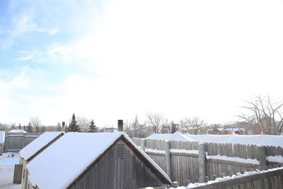 Snow covered houses and buildings against sky