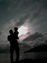 Scenic view of sea against cloudy sky at sunset