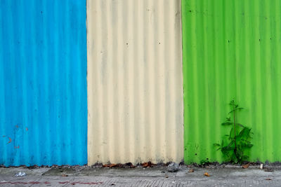 Blue metal grate of green wall